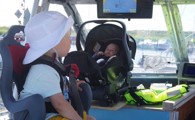 Båda barnen har varsin bra sittplats då vi båda vuxna ombord behövs för båten. 